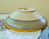 A yellow and black handpainted ceramic sink on a tiled table, showcasing a fish scale pattern inspired by Moroccan design.