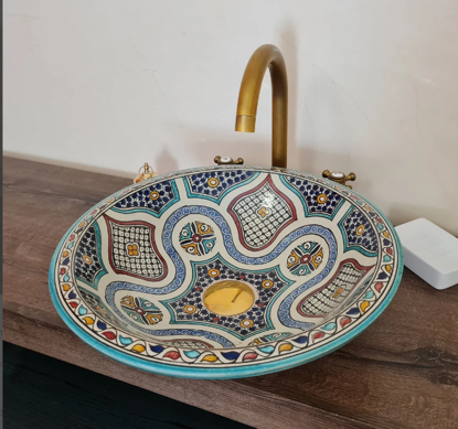 Boho-style bathroom featuring a handmade Moroccan ceramic vessel sink with mid-century design on a wooden vanity top.