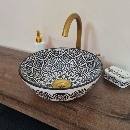 Handmade black and white Moroccan wash basin with intricate patterns and a gold faucet, showcasing Mediterranean elegance.