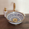 A decorative blue and white bowl with gold accents is displayed on a wooden counter, reflecting boho and mid-century styles.