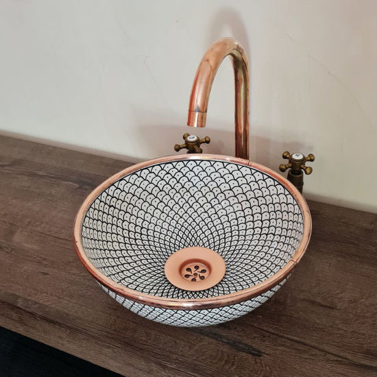 Handcrafted white ceramic sink with a solid copper rim and fishscale design, featuring a stylish copper faucet above it.