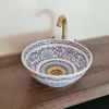 A blue and white ceramic bowl with intricate patterns, featuring a gold faucet, showcasing Moroccan craftsmanship and design.