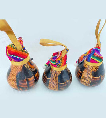 Three small wooden ornaments featuring colorful designs, handcrafted by Peruvian artisans using traditional mate burilado techniques.
