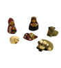 Seven miniature nativity figurines, handmade from natural clay and intricately painted, representing a traditional Holy Family.
