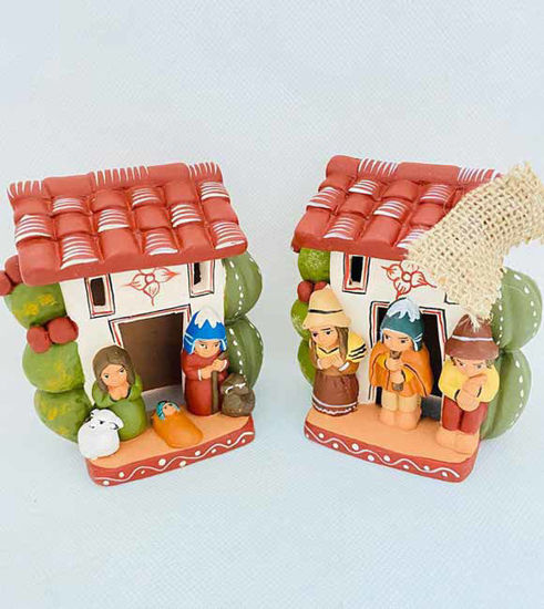 Two handmade ceramic figurines of a house with a man and woman, part of a vintage Peruvian nativity scene set.