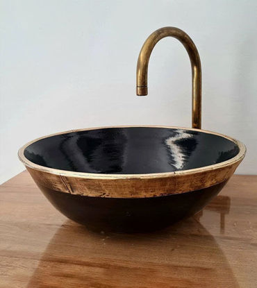 Black ceramic bowl with an aged brass rim and faucet, showcasing Moroccan craftsmanship and intricate sea-scale patterns.
