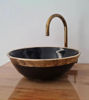 Elegant black and gold bowl featuring a brass faucet, highlighting traditional Moroccan craftsmanship and artistic detail.
