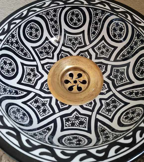 Hand-painted black and white terracotta sink with a gold handle, showcasing intricate Moroccan patterns and Mediterranean charm.