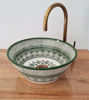 Artisan-crafted green and white bowl sink with a gold faucet, featuring intricate hand-painted designs inspired by Moroccan art.