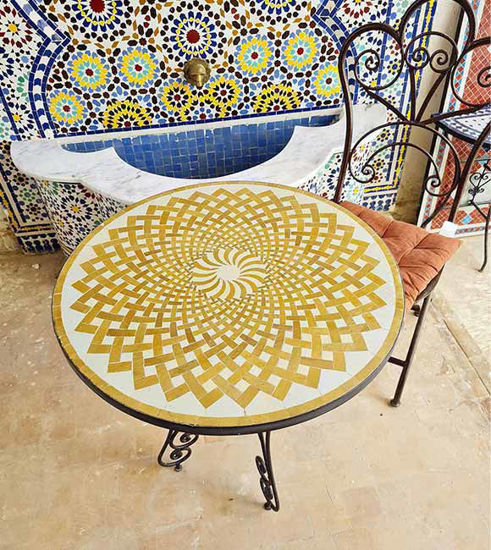 Round golden mosaic table with intricate designs showcasing Moroccan craftsmanship and mid-century style.