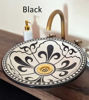 Black and white bathroom sink featuring a gold faucet, showcasing a blend of modern and mid-century design elements.