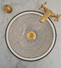 Handcrafted gold and black ceramic sink with a fish-scale pattern and gold faucet, showcasing Moroccan artistry and elegance.