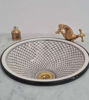 Elegant black and white ceramic sink with a gold faucet, adorned with a unique fish-scale design, reflecting Moroccan craftsmanship.