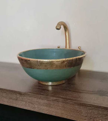 Emerald green ceramic bowl with gold faucet on a wooden counter, showcasing Moroccan fish scale design and artisan craftsmanship.
