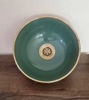 Vibrant green ceramic bowl with brushed brass faucet atop a wooden counter, highlighting Moroccan artistry and elegant design.
