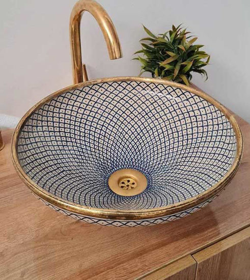 A handmade Fez Blue ceramic sink with a gold faucet and fish scale design, showcasing Moroccan craftsmanship and elegance.