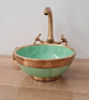 Artisan-crafted green bowl sink with a gold faucet and brass handle, highlighting unique Moroccan ceramic artistry.