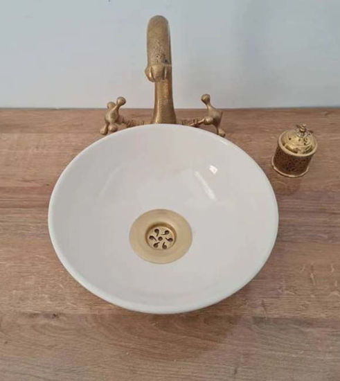 A white ceramic vessel sink with a gold faucet, showcasing minimalist hand-painted design, perfect for modern bathrooms.