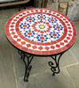 Close-up of a handmade mosaic table featuring a red and white design, suitable for indoor or outdoor use.