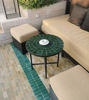Vibrant emerald green mosaic coffee table on a green tile floor, highlighting Moroccan artistry and versatile design for any space.