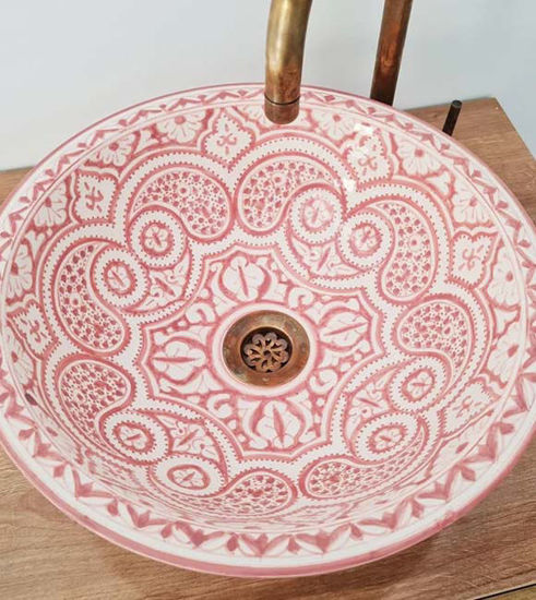 Hand-painted dusty pink ceramic sink with intricate designs and a golden faucet, showcasing Moroccan craftsmanship and style.