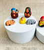 Miniature nativity scene set of handmade clay figurines on a white box, featuring detailed hand-painted designs for Christmas décor.