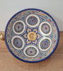 Artisan-made Moroccan sink featuring a gold faucet and vibrant blue and white patterns, blending art with functionality.