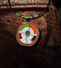 Handmade Maasai beaded necklace featuring multicolored beads and a natural cowrie shell centerpiece, celebrating cultural artistry.
