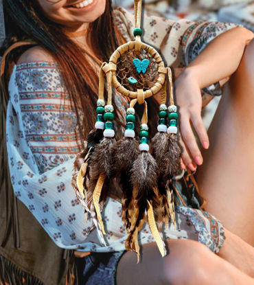 Handmade dream catcher with feathers and beads, symbolizing protection and positive dreams, hanging from a string.