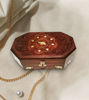 A handcrafted rosewood jewelry box featuring an intricate elephant inlay, adorned with gold chains and pearls for elegance.
