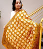 Vibrant orange scarf with geometric designs, made of pure silk, reflecting artisan craftsmanship and ethnic Indian style.