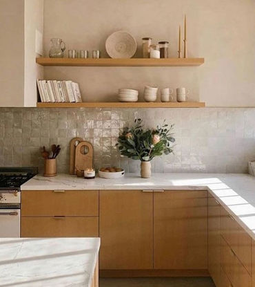 A kitchen featuring wooden cabinets and shelves, accented by off-white handmade Moroccan Zellige tiles on the backsplash.