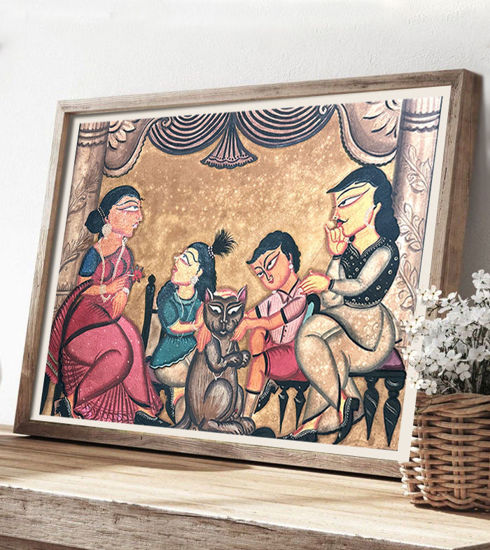 Framed Patachitra painting of a family around a table, featuring vibrant colors and a whimsical cat in a village setting.