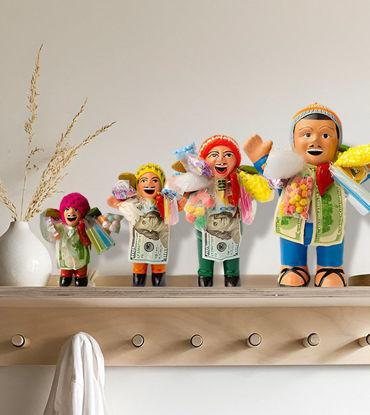 Group of handcrafted Ekeko dolls in diverse outfits, representing prosperity and good fortune, made by Peruvian artisans.