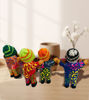 Handmade dolls with colorful attire and hats, embodying the Ekeko, a Peruvian figure symbolizing wealth and good fortune.
