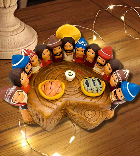 Wooden table displaying handmade terracotta figurines of Jesus and his disciples from the Last Supper, crafted by Peruvian artisans.