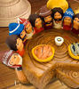 Figurines of Jesus and his disciples on a wooden table, representing the Last Supper, handcrafted from terracotta by Peruvian artisans.