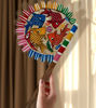 Colorful hand-painted wooden fan featuring intricate fish designs, showcasing Bengal Pattachitra folk art for home decor.