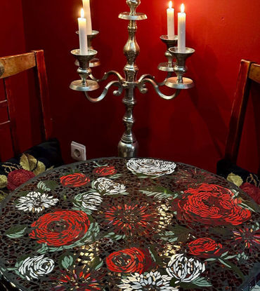 A red floral mosaic tile table, showcasing gold accents and vibrant ceramic design.