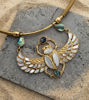 Egyptian-inspired scarab choker necklace with wings, featuring a gold pendant, golden pearl, and abalone inlay.