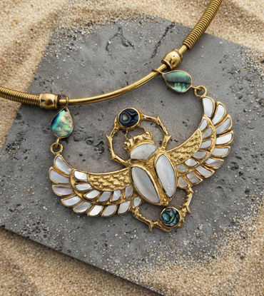 Egyptian-inspired scarab choker necklace with wings, featuring a gold pendant, golden pearl, and abalone inlay.