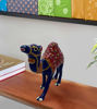 Handcrafted metal camel figurine with gold decorations, featuring intricate saddle motifs and a glossy finish.