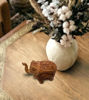 Antique-inspired brown wooden elephant figurine with intricate carvings, displayed on a white background.