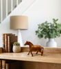 Brown wooden horse figurine on a white background, showcasing a rustic design for play and home décor.