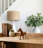 Brown wooden horse figurine on a white background, showcasing a rustic design for play and home décor.